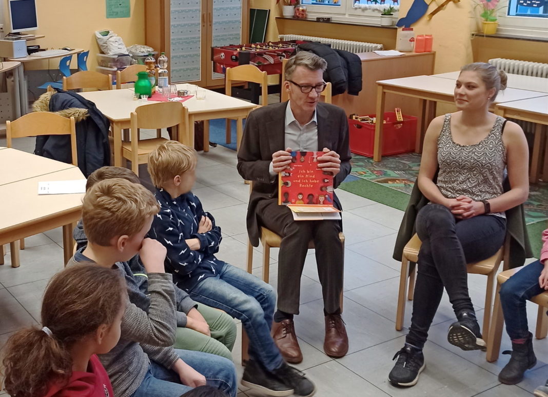 Gemeinsam mit den Schülerinnen und Schülern und Lehrkraft Janina Kern las Sven Wolf (SPD) eine Kurzgeschichte zum Thema Kinderrechte. Foto: Jeremias Düring