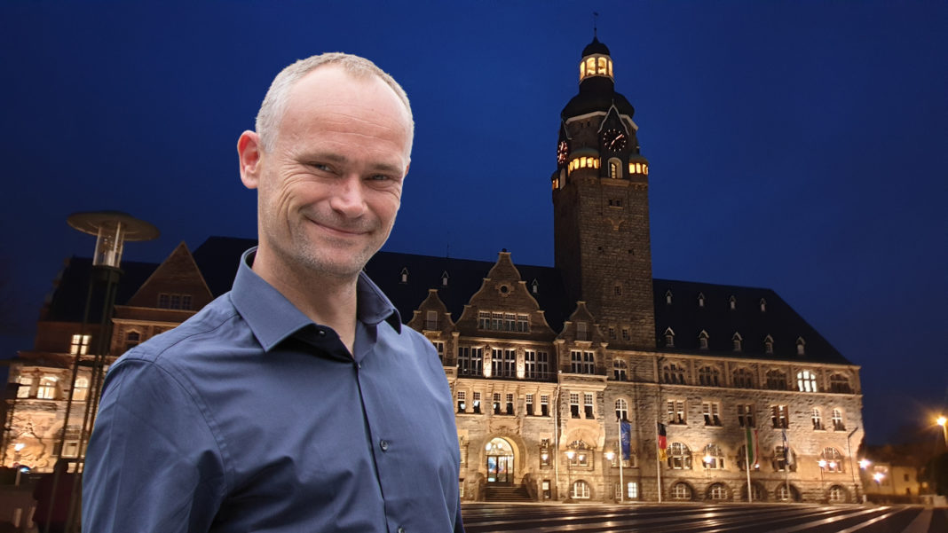 David Schichel, Fraktionsvorsitzender B90/Die GRÜNEN Remscheid vor dem Remscheider Rathaus. Collage: Sascha von Gerishem
