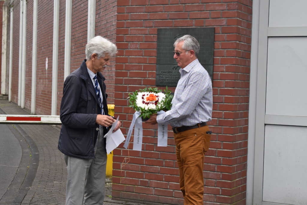 Hans Heinz Schumacher, 1. Vorsitzender der Gedenk- und Bildungsstätte Pferdestall, übergibt Blumen an Peter Auwerda. Foto: Peter Klohs