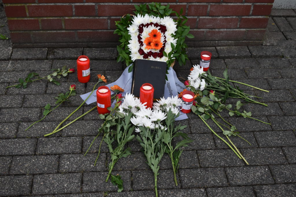 Die alte Bibel mit Blumen und Kerzen unter der Gedenktafel. Foto: Peter Klohs