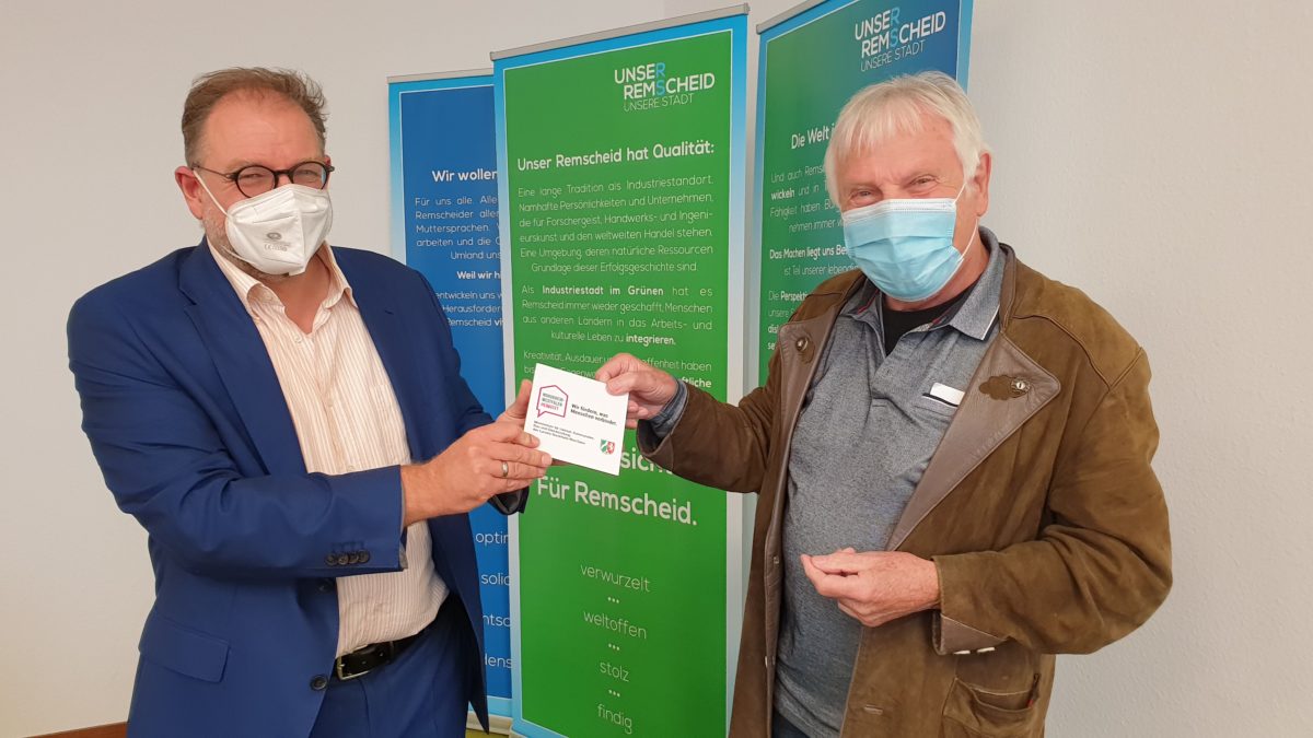 Im Rathaus Remscheid übergab Baudezernent Peter Heinze eine Plakette an Dirk Bosselmann, mit der auf die Inanspruchnahme von Landesmitteln für das Wasserspiel in Lüttringhausen hingewiesen wird. Foto: Sascha von Gerishem