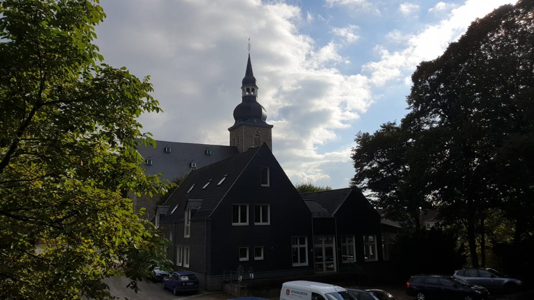 Das Gemeindehaus der evangelischen Kirchengemeinde Lüttringhausen aus Richtung der Heimatbühne, mit der Stadtkirche im Hintergrund. Foto: Sascha von Gerishem