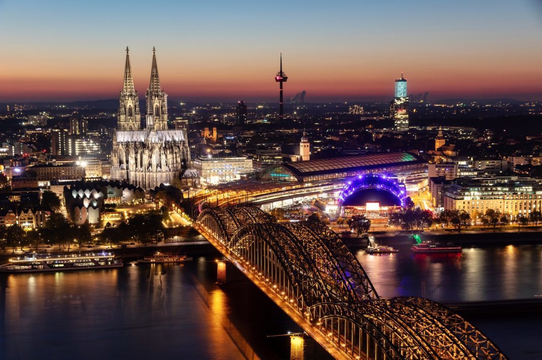 Köln am Abend mit illuminiertem Kölner Dom. Foto: Herbert Aust