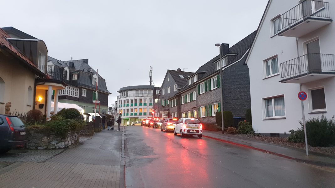 Menschen warten auf die Corona-Testung, falschparkende Autos nicht in Sicht. Foto: Sascha von Gerishem